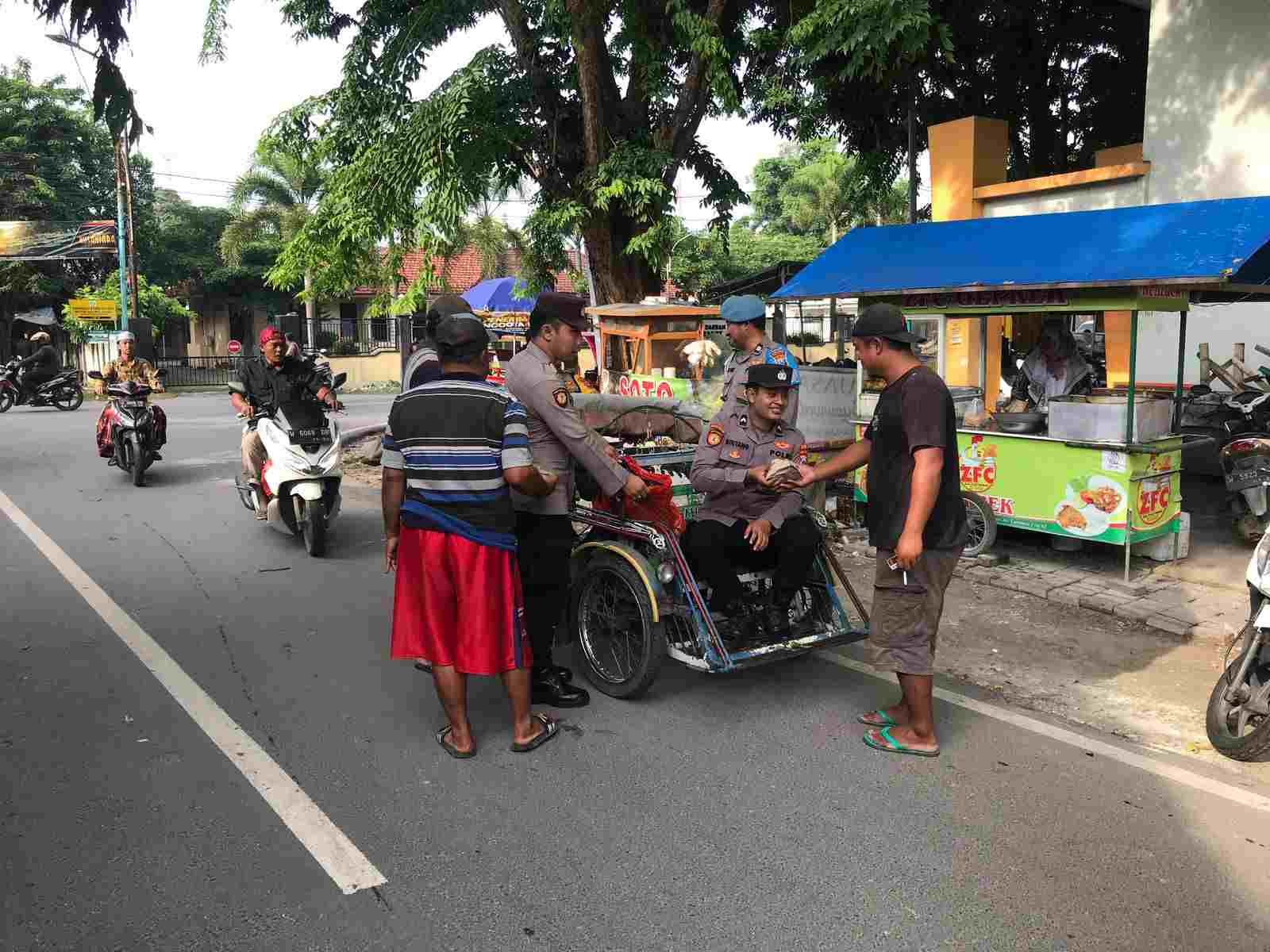 Berbagi Kebahagiaan, Kapolsek Sidayu Gresik Bagikan Nasi Bungkus diatas Becak